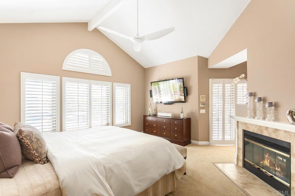 9369 Quail Canyon Road El Cajon, CA 92021 - Photo 27 of 43 a spacious bedroom with a bed a fireplace and a large window