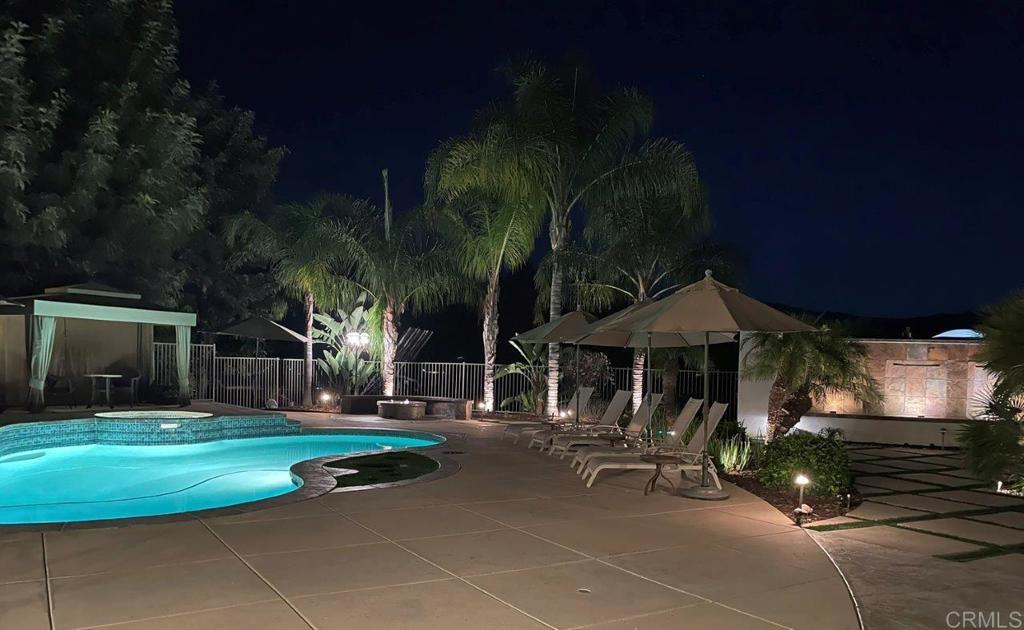 9369 Quail Canyon Road El Cajon, CA 92021 - Photo 39 of 43 a view of a patio with table and chairs under an umbrella with a yard