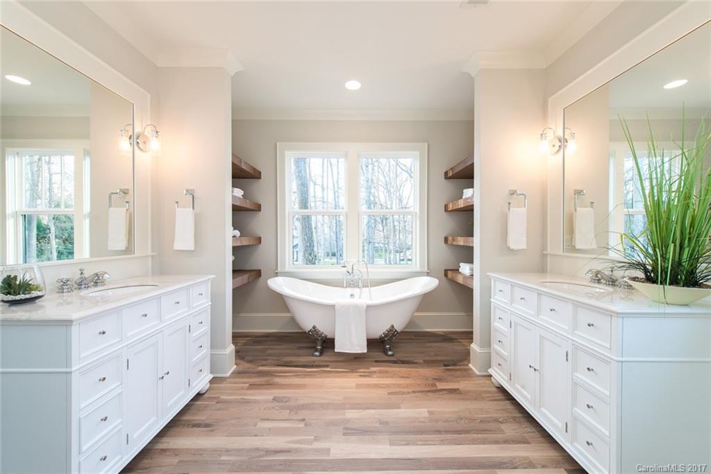 501 McAlway Road Charlotte, NC 28211 - Photo 19 of 24 a spacious bathroom with a double vanity sink large mirror and a bathtub