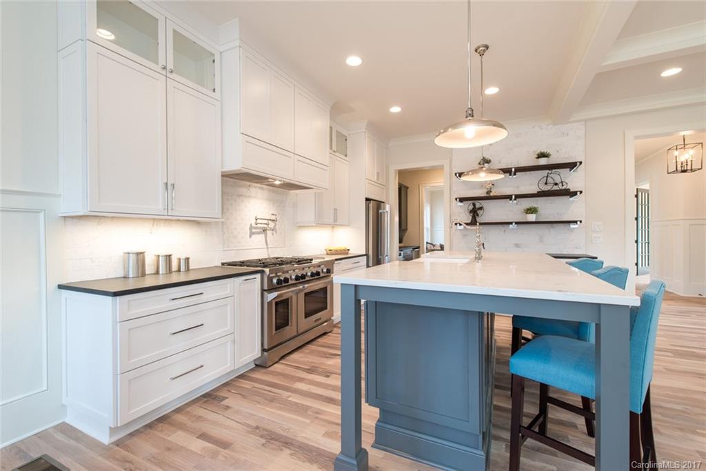 501 McAlway Road Charlotte, NC 28211 - Photo 5 of 24 a kitchen with stainless steel appliances kitchen island granite countertop a table chairs stove and white cabinets