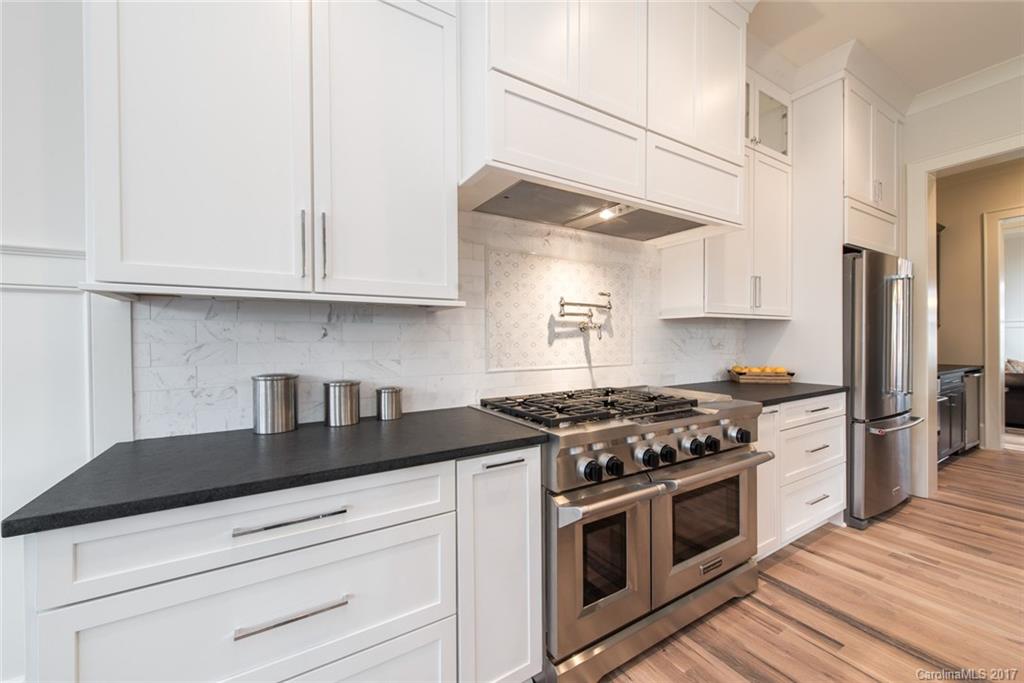 501 McAlway Road Charlotte, NC 28211 - Photo 8 of 24 a kitchen with granite countertop white cabinets and stainless steel appliances