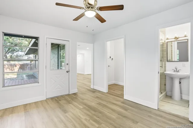 a view of an empty room with window and wooden floor