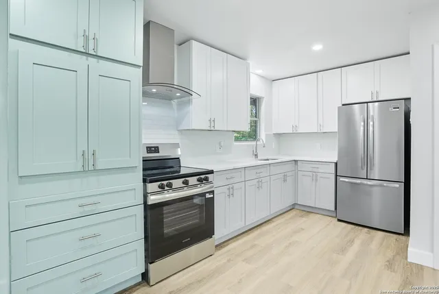 a kitchen with cabinets appliances and wooden floor
