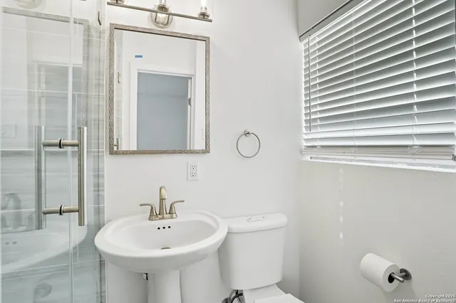 a bathroom with a sink a toilet and mirror