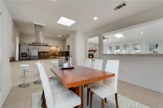 a kitchen with stainless steel appliances kitchen island dining table and chairs