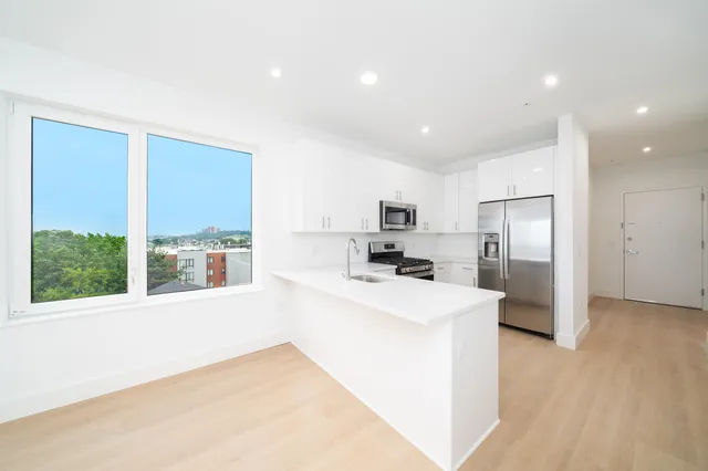 a kitchen with stainless steel appliances a refrigerator and a stove top oven