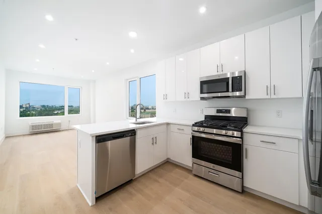 a kitchen with stainless steel appliances a stove sink microwave and cabinets