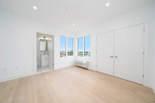 a view of a big room with windows and refrigerator