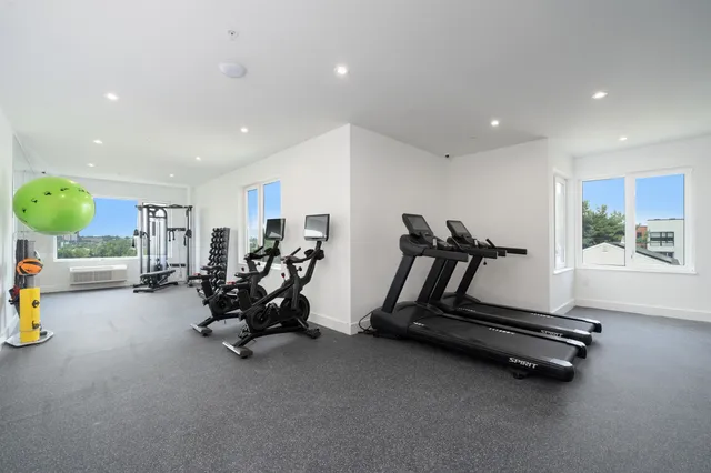 a view of a room with gym equipment and floor to ceiling window