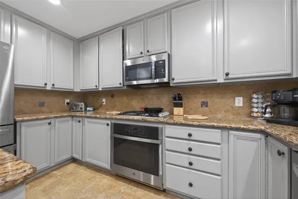 a kitchen with granite countertop cabinets stainless steel appliances and a sink