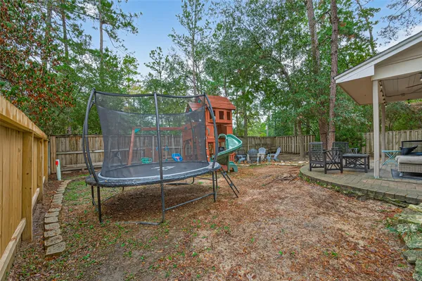an aerial view of residential house with outdoor space and trees all around