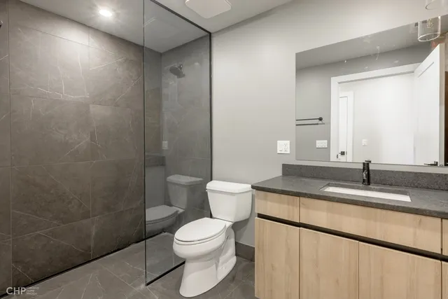 a bathroom with a granite countertop sink a toilet and a shower