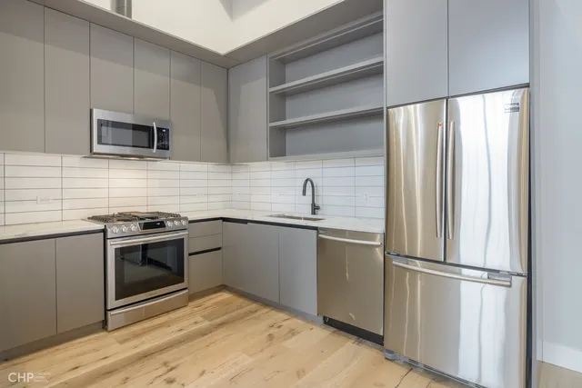 a kitchen with stainless steel appliances granite countertop a refrigerator and a sink