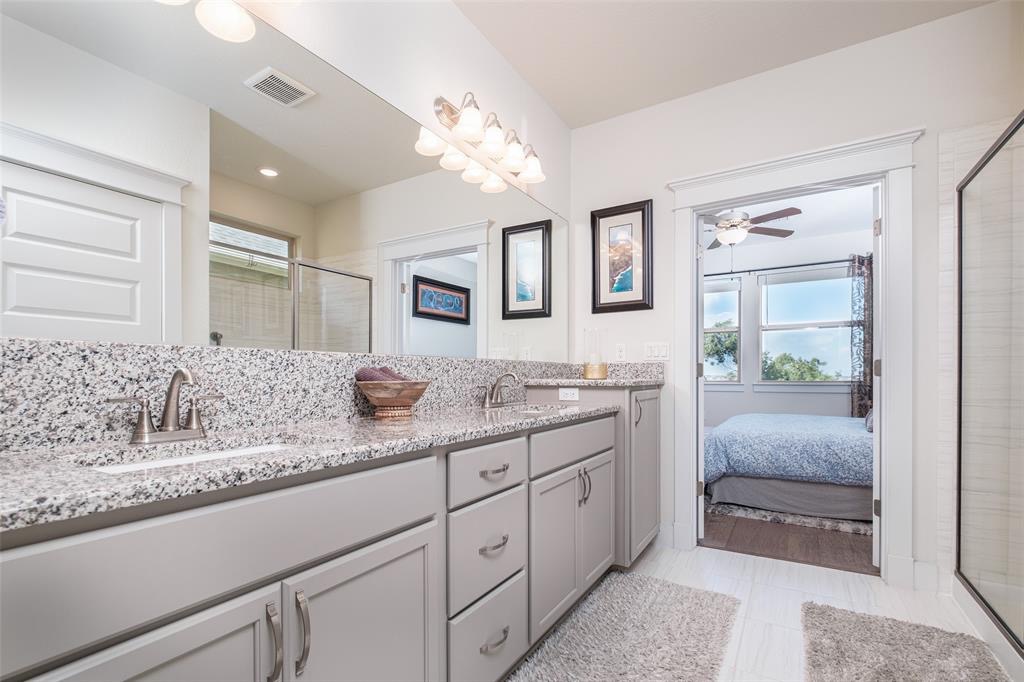 1724 Rowdy Loop Leander, TX 78641 - Photo 13 of 32 Ensuite bathroom with double vanity, a shower stall, and ceiling fan