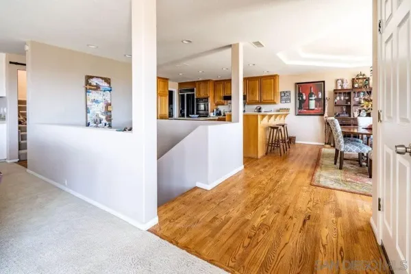 a kitchen with stainless steel appliances granite countertop a table chairs a sink and a refrigerator