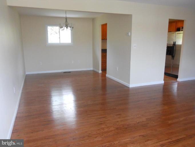 8820 Sigrid Road Randallstown, MD 21133 - Photo 3 of 23 an empty room with wooden floor and windows