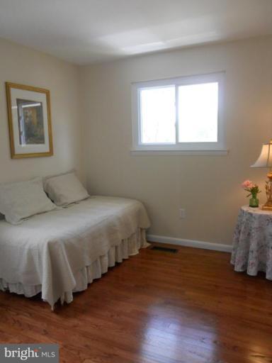 8820 Sigrid Road Randallstown, MD 21133 - Photo 21 of 23 a bedroom with a bed and wooden floor
