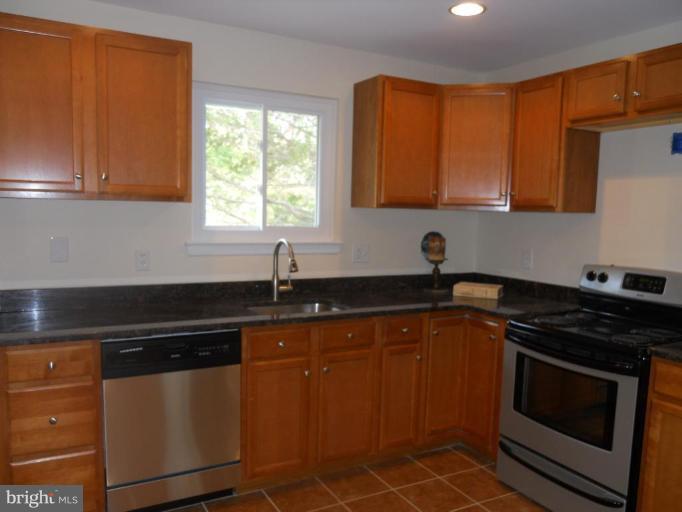 8820 Sigrid Road Randallstown, MD 21133 - Photo 4 of 23 a kitchen with granite countertop a sink stove and cabinets
