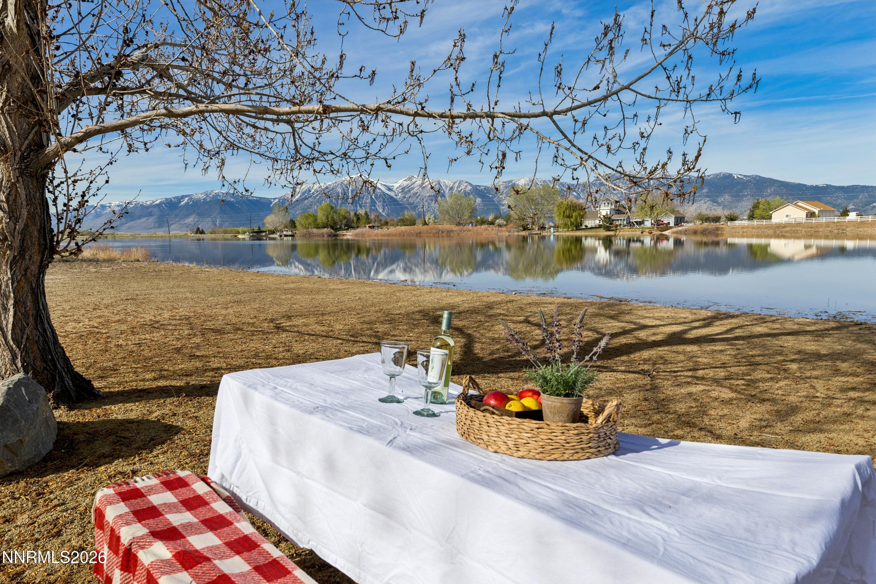 1608 East Valley Road Gardnerville, NV 89410 - Photo 29 of 54 a view of a lake with a bench and trees in the background