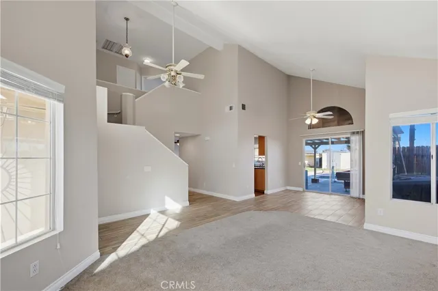 a view of an empty room with wooden floor fireplace and a window