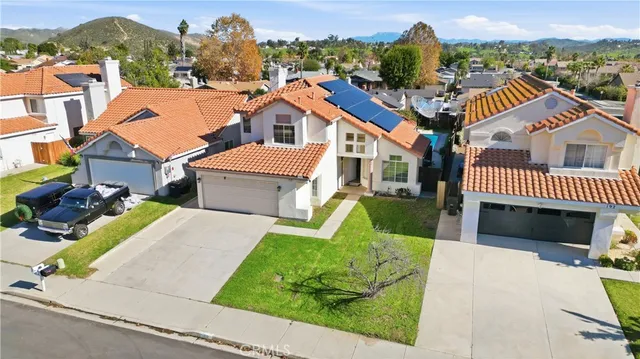 an aerial view of residential houses with outdoor space and parking