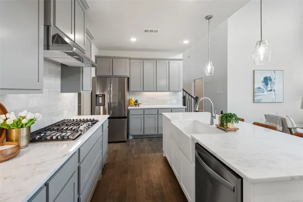 a kitchen with a sink stainless steel appliances a counter space and cabinets