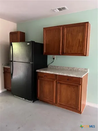 a kitchen with refrigerator and cabinets