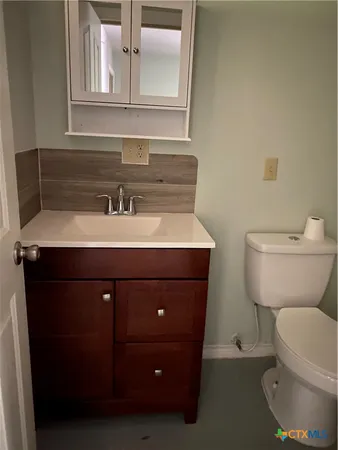 a bathroom with a toilet a sink and mirror