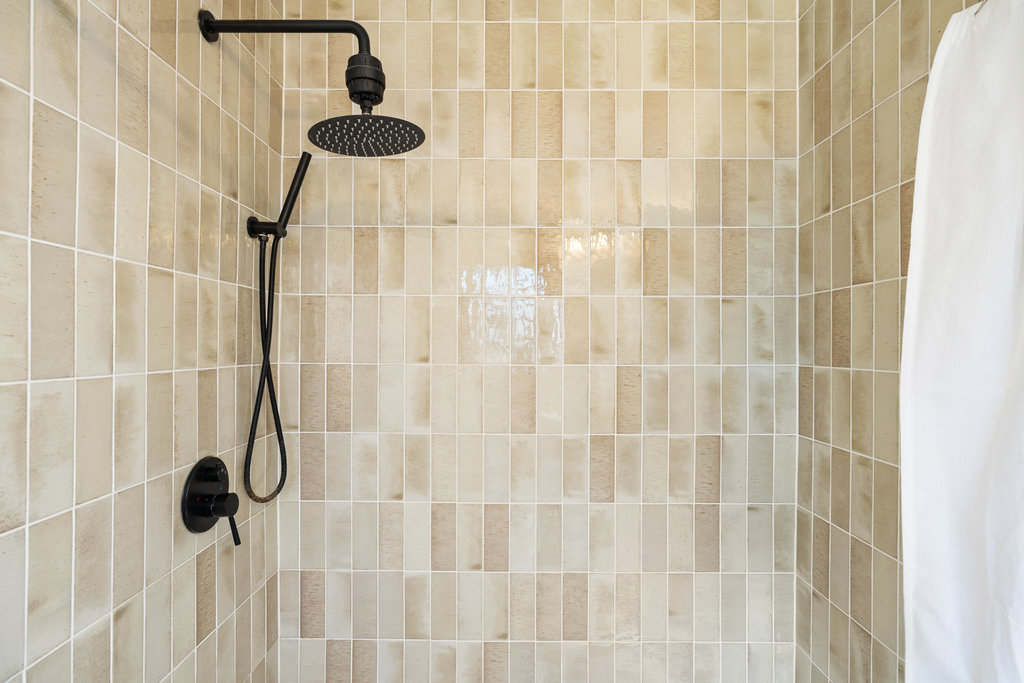 2008 Matthews Lane Austin, TX 78745 - Photo 24 of 36 The walk-in shower is wrapped in tile that gives it just enough modern edge while still fitting the home’s easy mid-century character