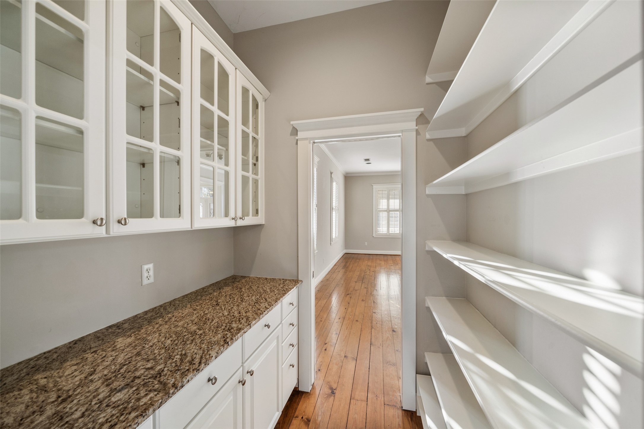 1342 Allston Street Houston, TX 77008 - Photo 15 of 39 Granite counters, glass-front cabinetry, and pocket doors make this butler’s pantry as functional as it is flexible.