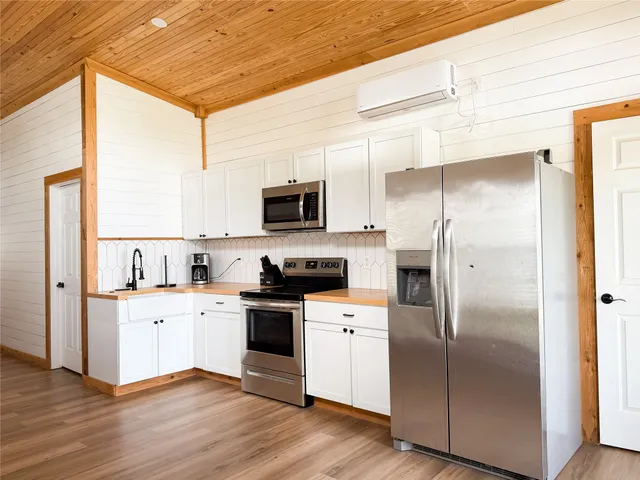 a kitchen with a refrigerator a sink dishwasher a stove and a microwave oven with cabinets