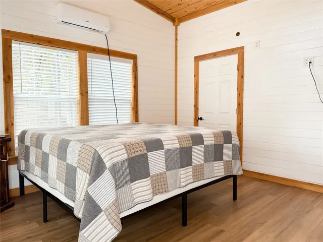 a bedroom with a bed and wooden floor