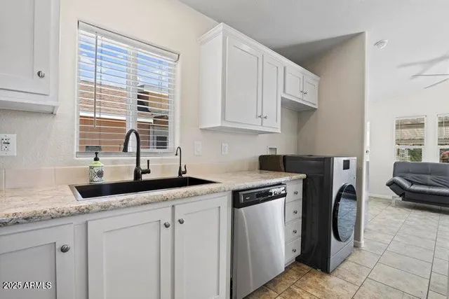 a kitchen with granite countertop a sink a stove a washer and dryer