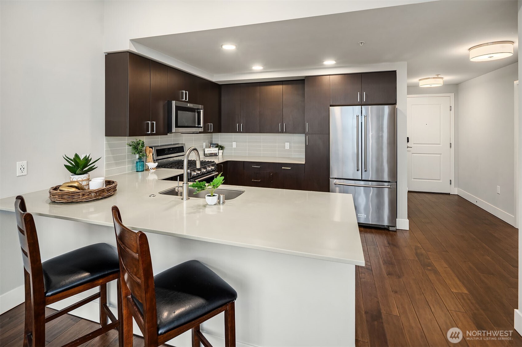 50 Pine Street, Unit 404 Edmonds, WA 98020 - Photo 13 of 33 a kitchen with stainless steel appliances a dining table chairs and refrigerator