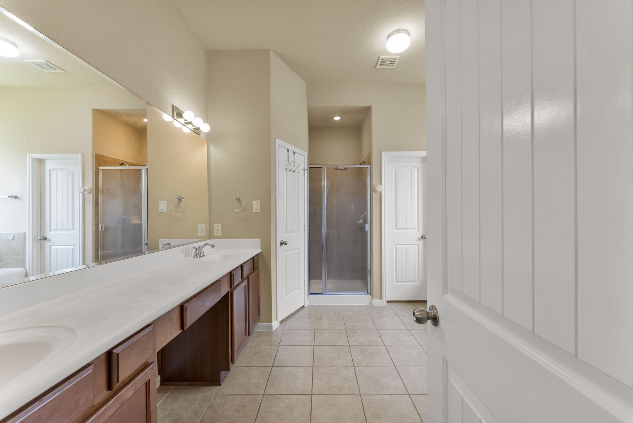 174 Maple Grove Drive Conroe, TX 77384 - Photo 13 of 26 The primary bath features dual sinks, tile flooring, a walk-in shower, and a soaking tub — everything you need to unwind.
