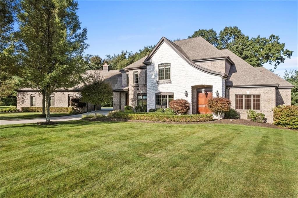 a view of a white house with a yard and plants