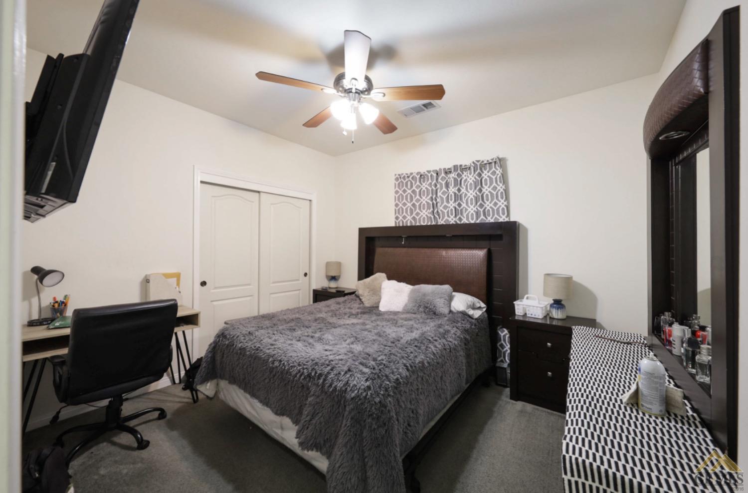 Undisclosed Address Bakersfield, CA 93306 - Photo 16 of 29 a bedroom with a bed and a chandelier