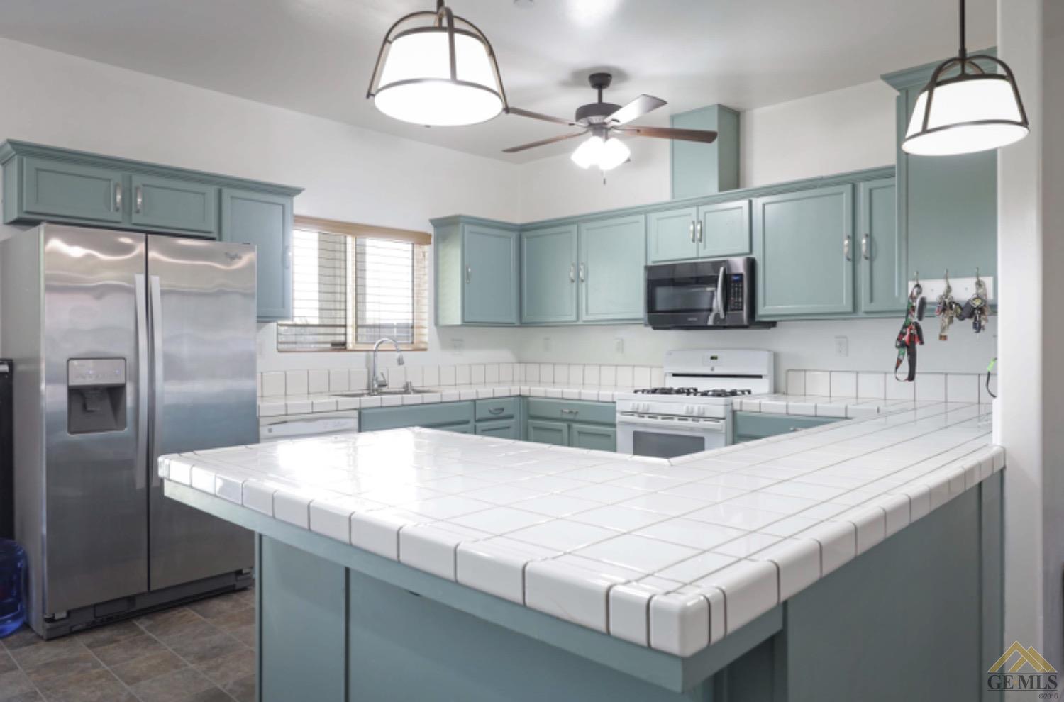 Undisclosed Address Bakersfield, CA 93306 - Photo 22 of 29 a kitchen with kitchen island granite countertop a sink a counter top space appliances and cabinets