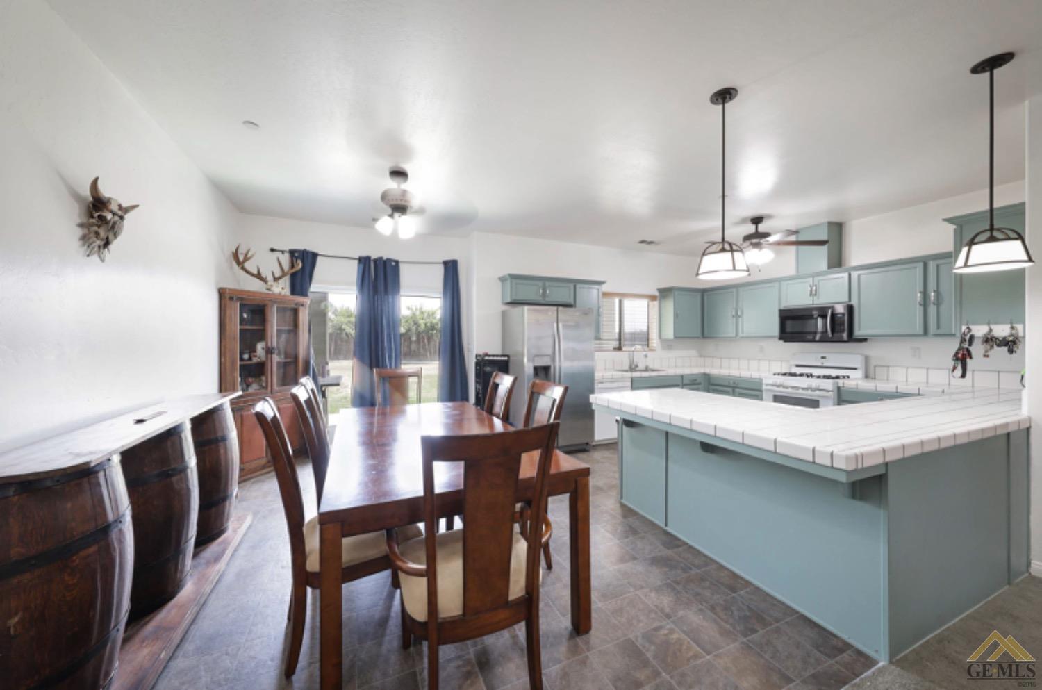 Undisclosed Address Bakersfield, CA 93306 - Photo 23 of 29 a kitchen with stainless steel appliances kitchen island granite countertop a sink a stove a dining table and chairs