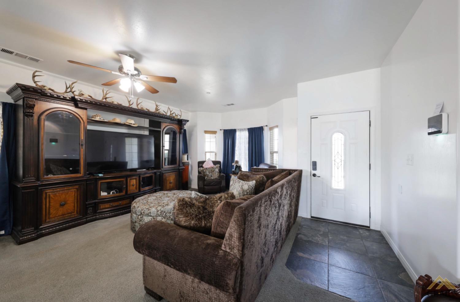Undisclosed Address Bakersfield, CA 93306 - Photo 7 of 29 a living room with furniture a flat screen tv and a chandelier