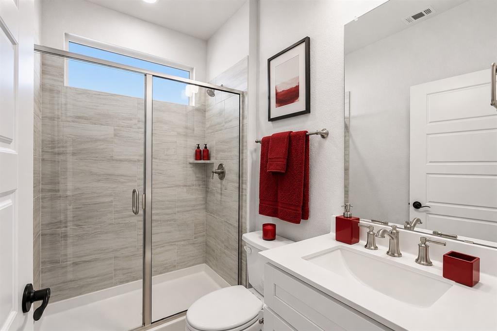 3311 Willena Road Melissa, TX 75454 - Photo 16 of 40 Shower with glass enclosure and light-hued tile surround, featuring a built-in shelf