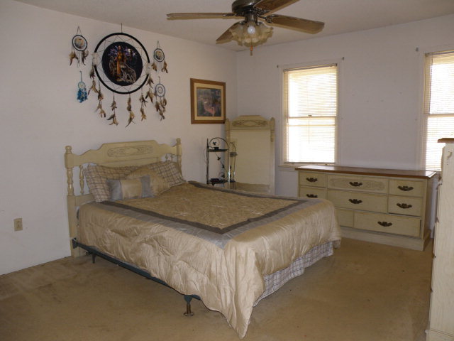 434 Homer Roberts Road Gray, GA 31032 - Photo 3 of 12 a bedroom with a bed and a chandelier