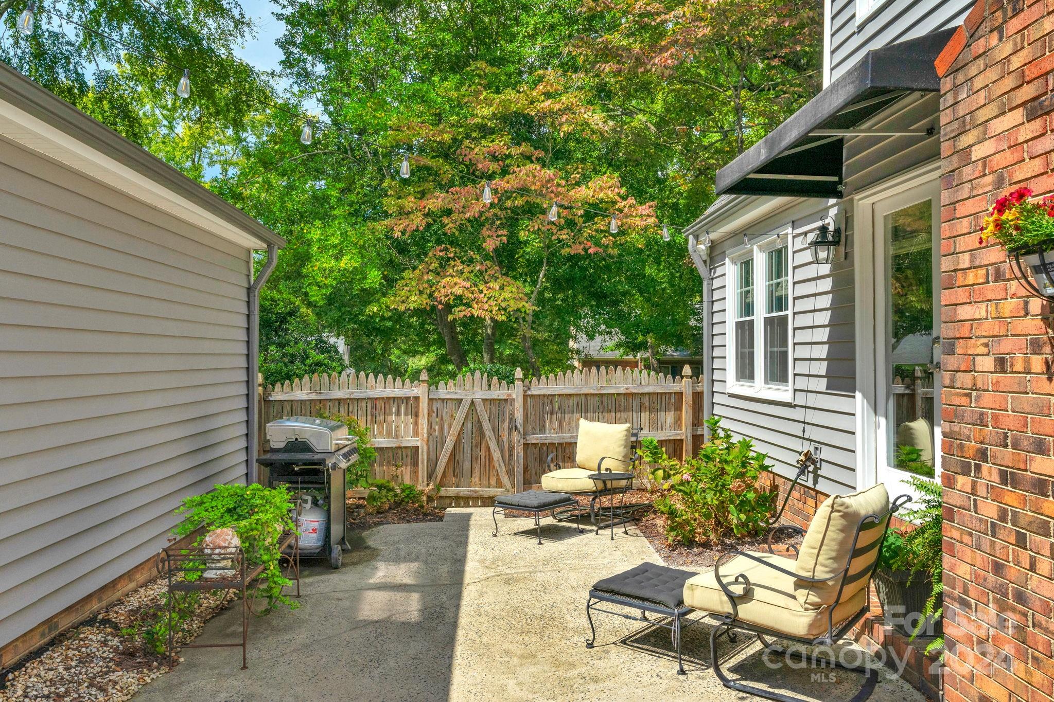 406 Sandymead Road Matthews, NC 28105 - Photo 40 of 48 a view of a chair and tables in the patio in front of the house