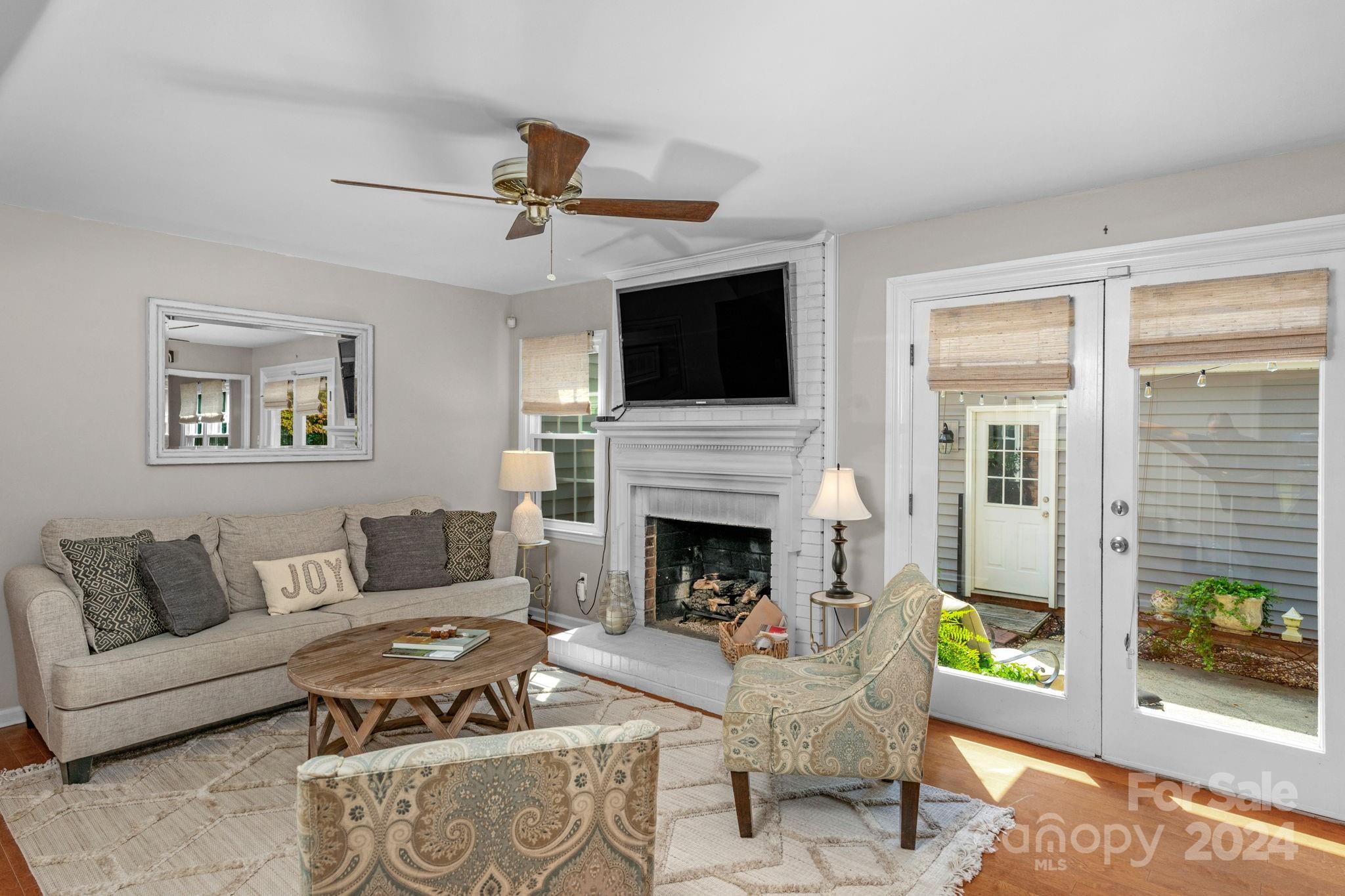 406 Sandymead Road Matthews, NC 28105 - Photo 9 of 48 a living room with furniture a flat screen tv and a fireplace