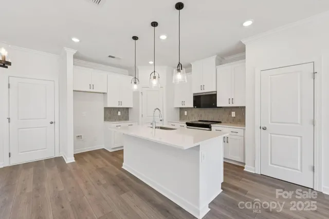 a kitchen with stainless steel appliances white cabinets sink and stove