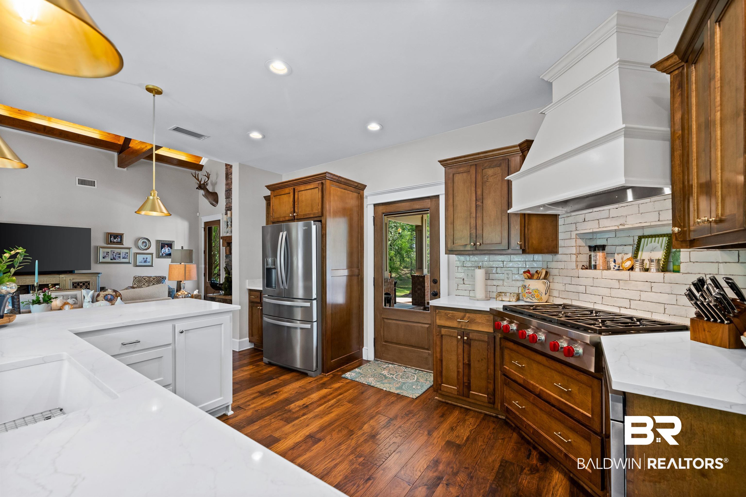47252 Emmons Road Bay Minette, AL 36507 - Photo 14 of 50 Kitchen featuring light stone countertops, stainless steel appliances, dark wood-style flooring, beamed ceiling, and hanging light fixtures