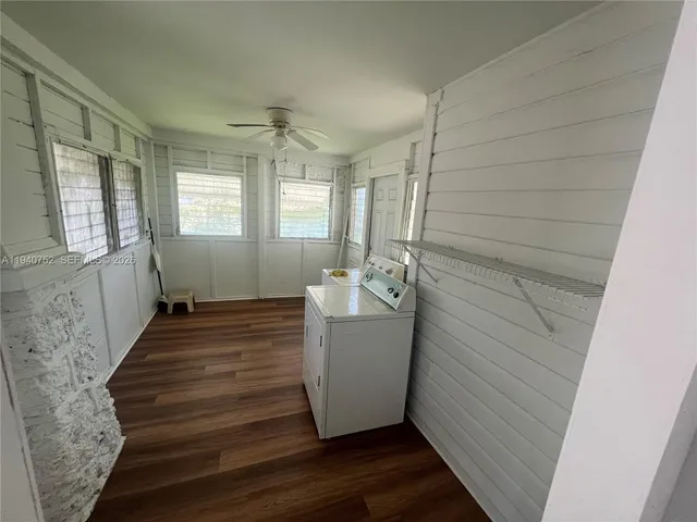 a room with a wooden floor and windows