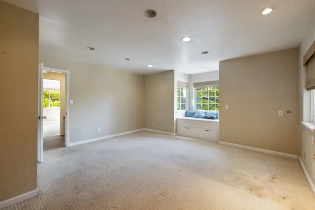 a view of an empty room with window and cabinet