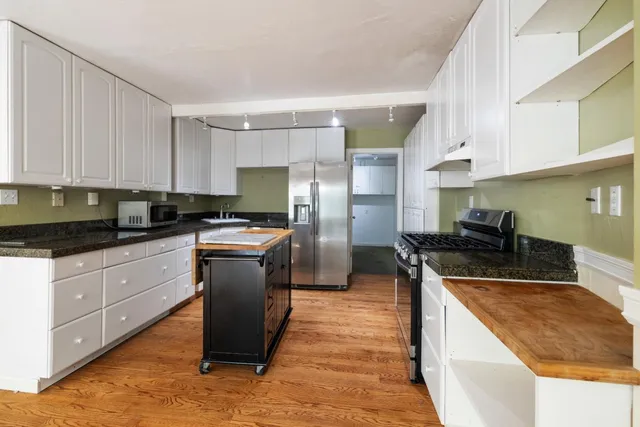 a kitchen with granite countertop a stove top oven and cabinets