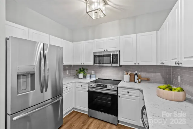 a kitchen with stainless steel appliances a refrigerator sink and microwave